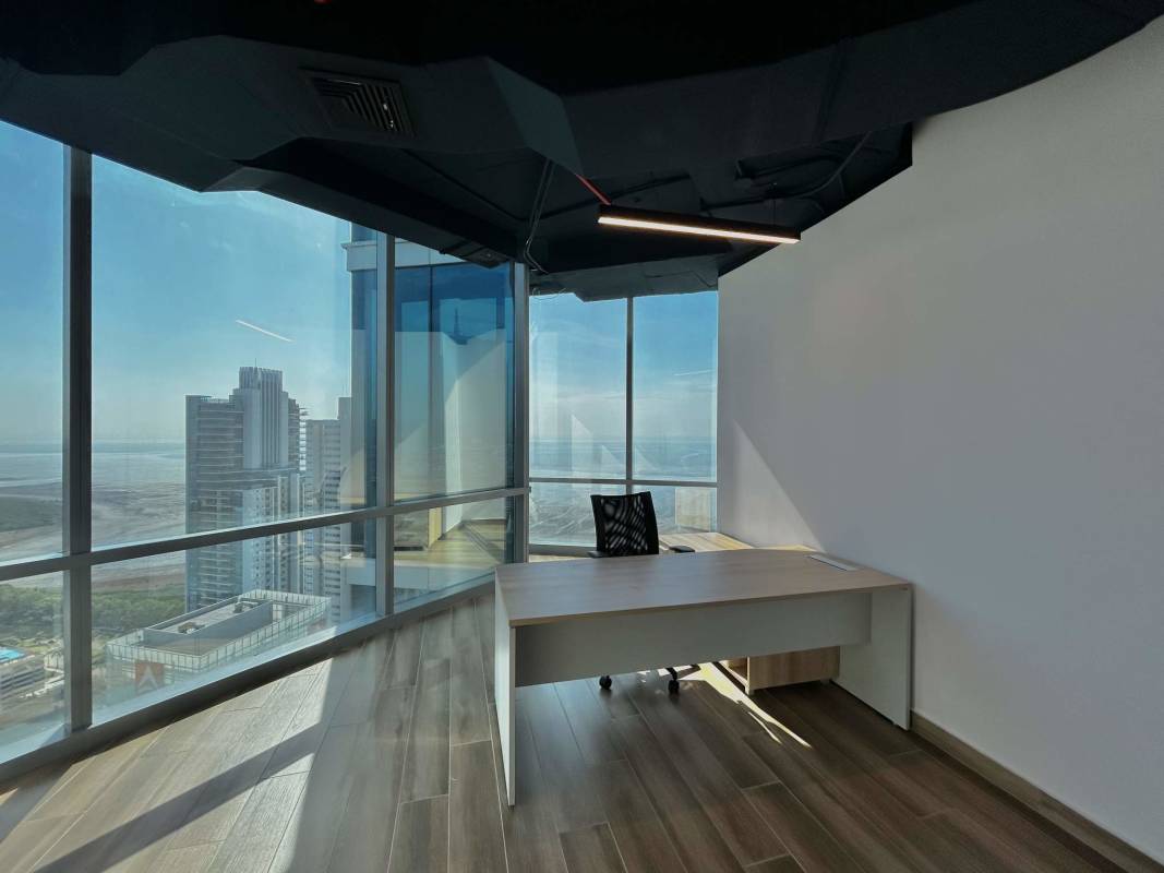 Workspace with panoramic skyline views through glass facade in Costa del Este tower