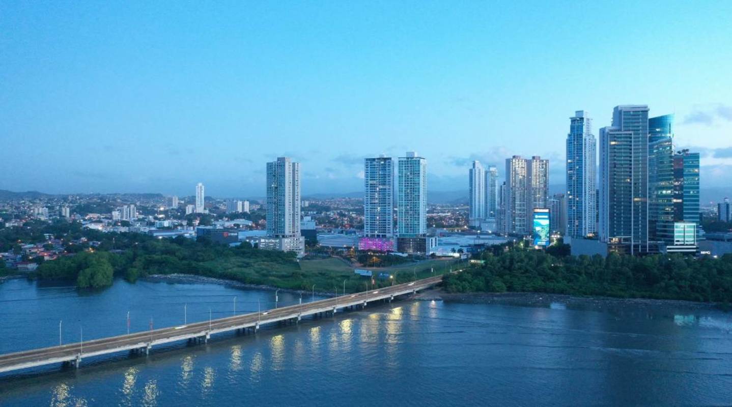 Aerial view of coastal Panama City skyline with Ipanema Residence twin towers, bridge over ocean, green parks