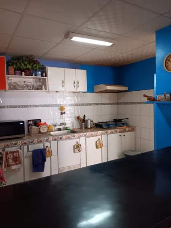 Living room with tiled floor, armchair, entertainment unit, dining area view in San Antonio Panama