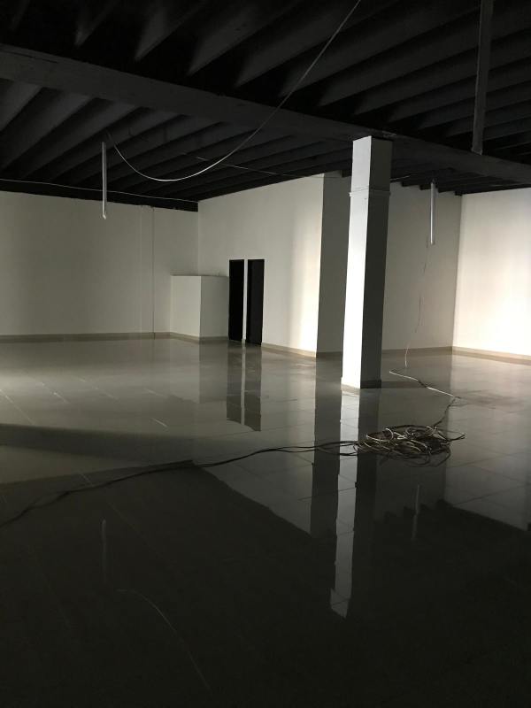 Open commercial unit with gray tiles, glass brick walls, metal railing at Hotel Panama Obarrio.