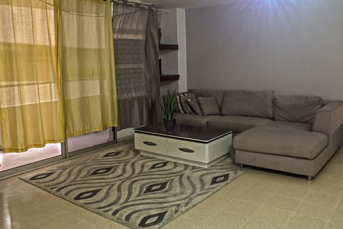 Spacious living room with sectional sofa, coffee table and large windows in PH Del Rey El Cangrejo Panama City