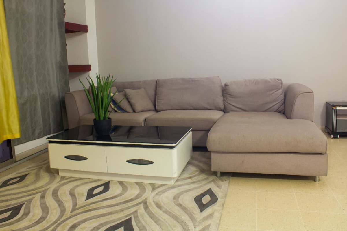 Living room in PH Del Rey apartment with sofa, TV, and natural light