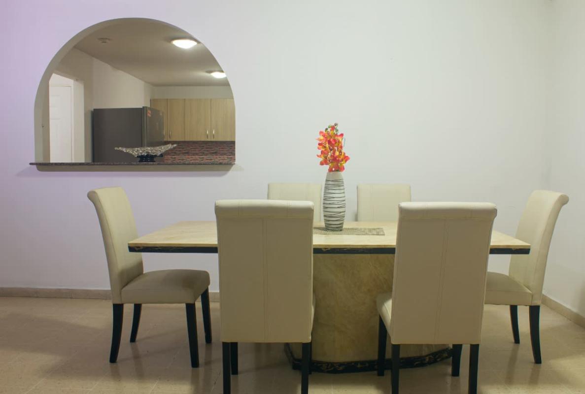 Bright hallway with neutral tiles and white doors at PH Del Rey apartment Panama