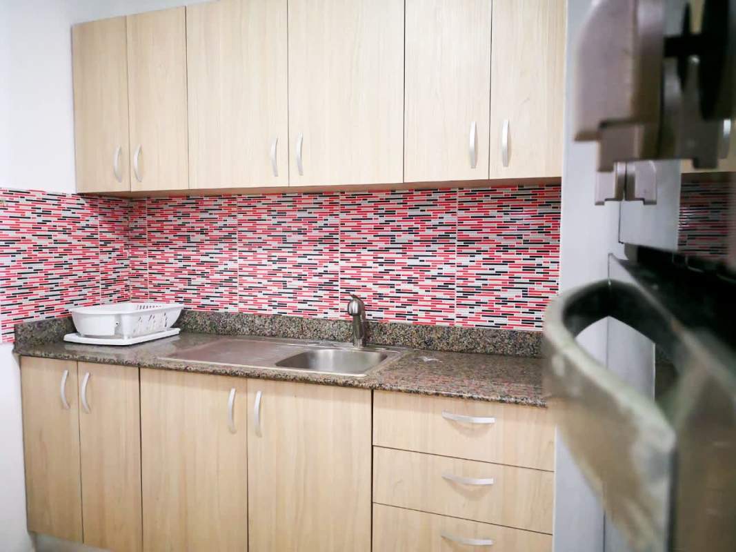 Kitchen with built-in oven, granite counters and colorful backsplash PH Del Rey apartment Panama City
