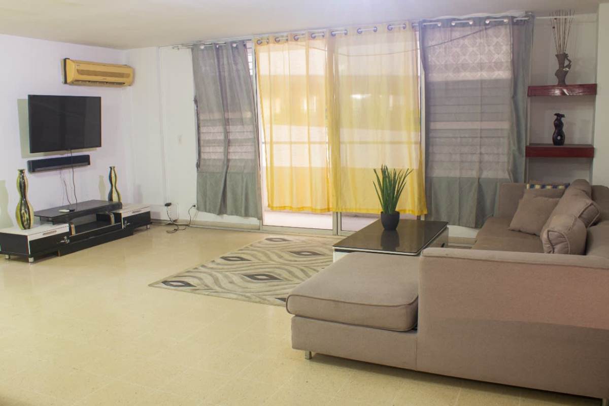 Spacious living room with curtains and TV at PH Del Rey apartment El Cangrejo Panama