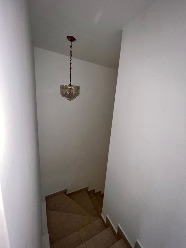 Internal staircase with arched window at Condado del Rey house for sale