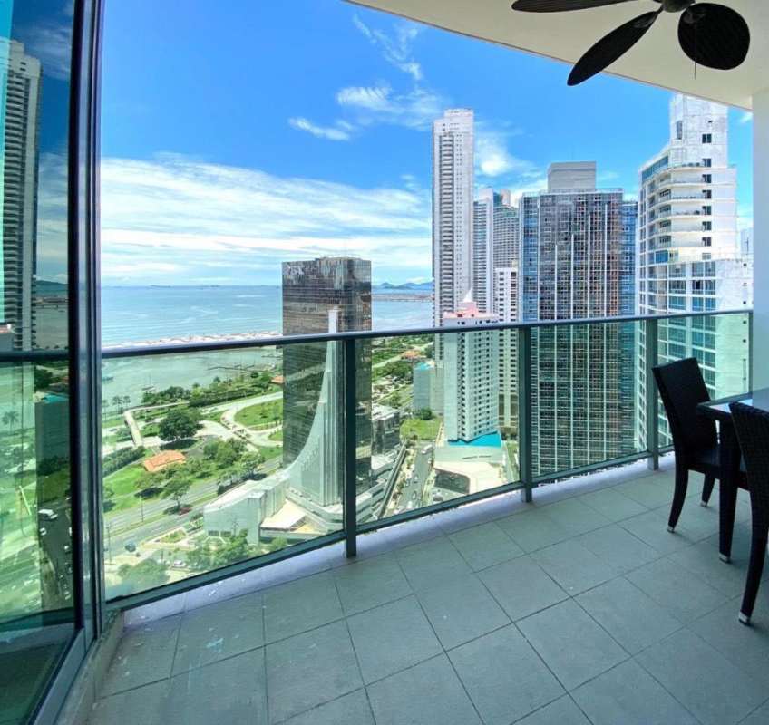 Covered balcony with outdoor dining set, ceiling fan, panoramic ocean and skyline view at PH BICSA Panama City