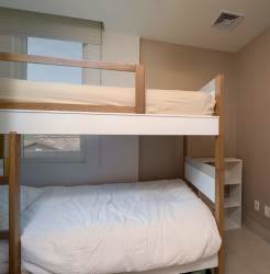 Spacious bedroom with king-size bed, balcony access and lake views in Buenaventura condo