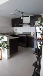 Modern kitchen with granite counters and appliances at PH Midrise Woodlands Panama