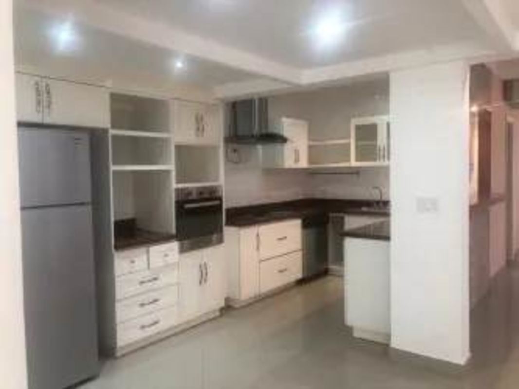 Contemporary white kitchen cabinetry and oven with hood in family house Clayton Panama