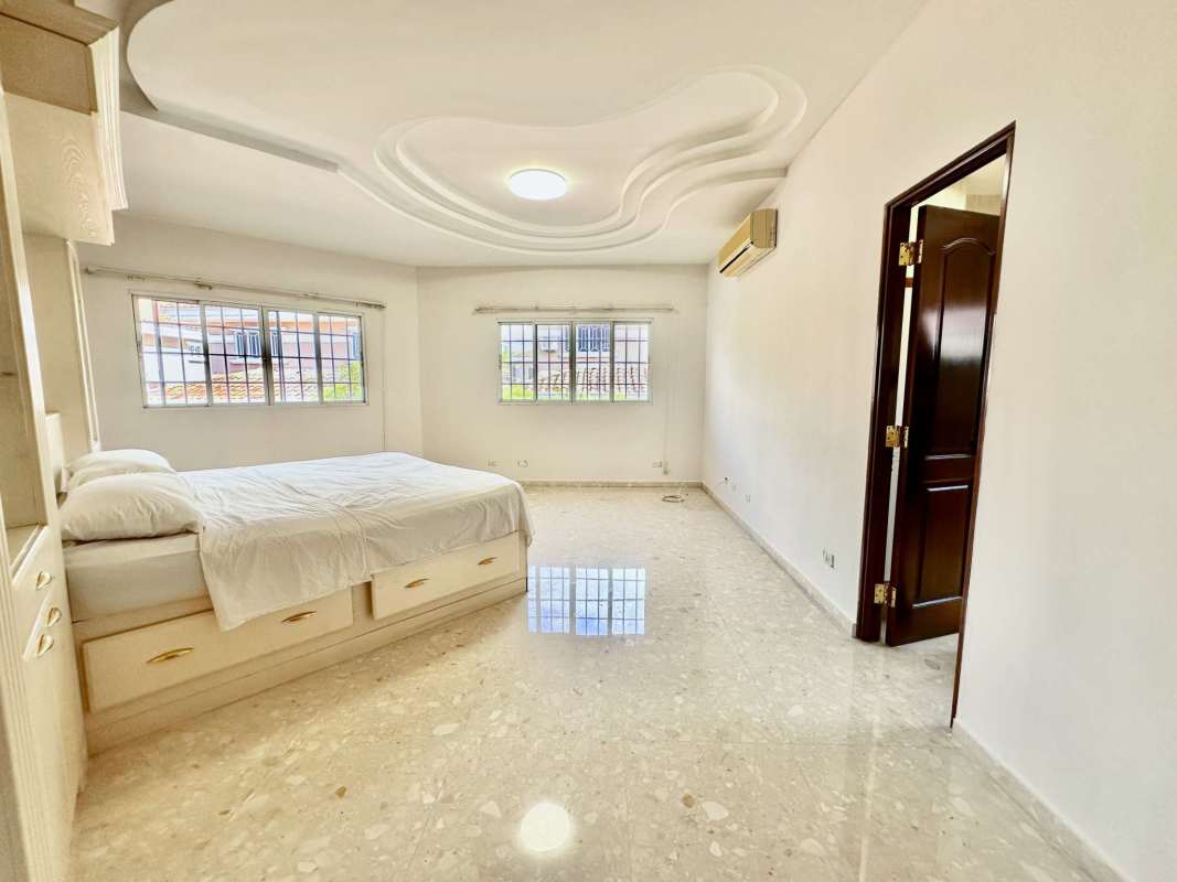 Spacious walk-in closet with built-in cabinets and marble flooring in Altos de Panama house