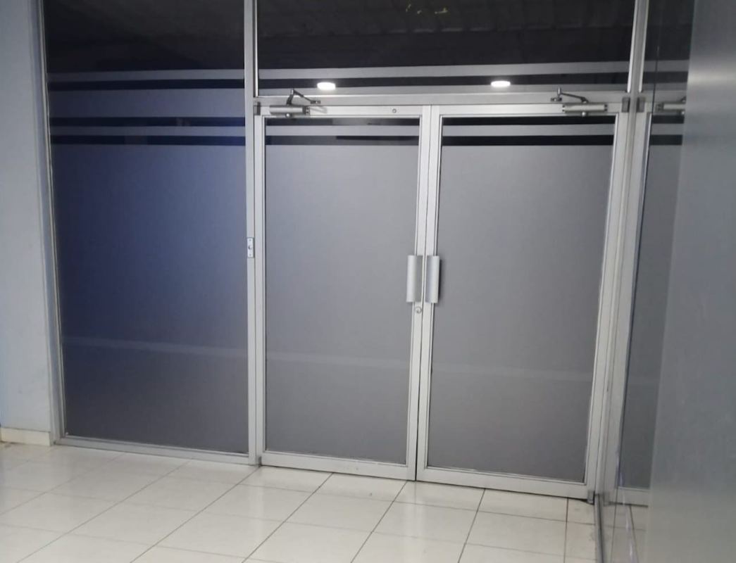Office entrance with frosted glass double doors metal frames in OfiDepósitos Central Calidonia Panama