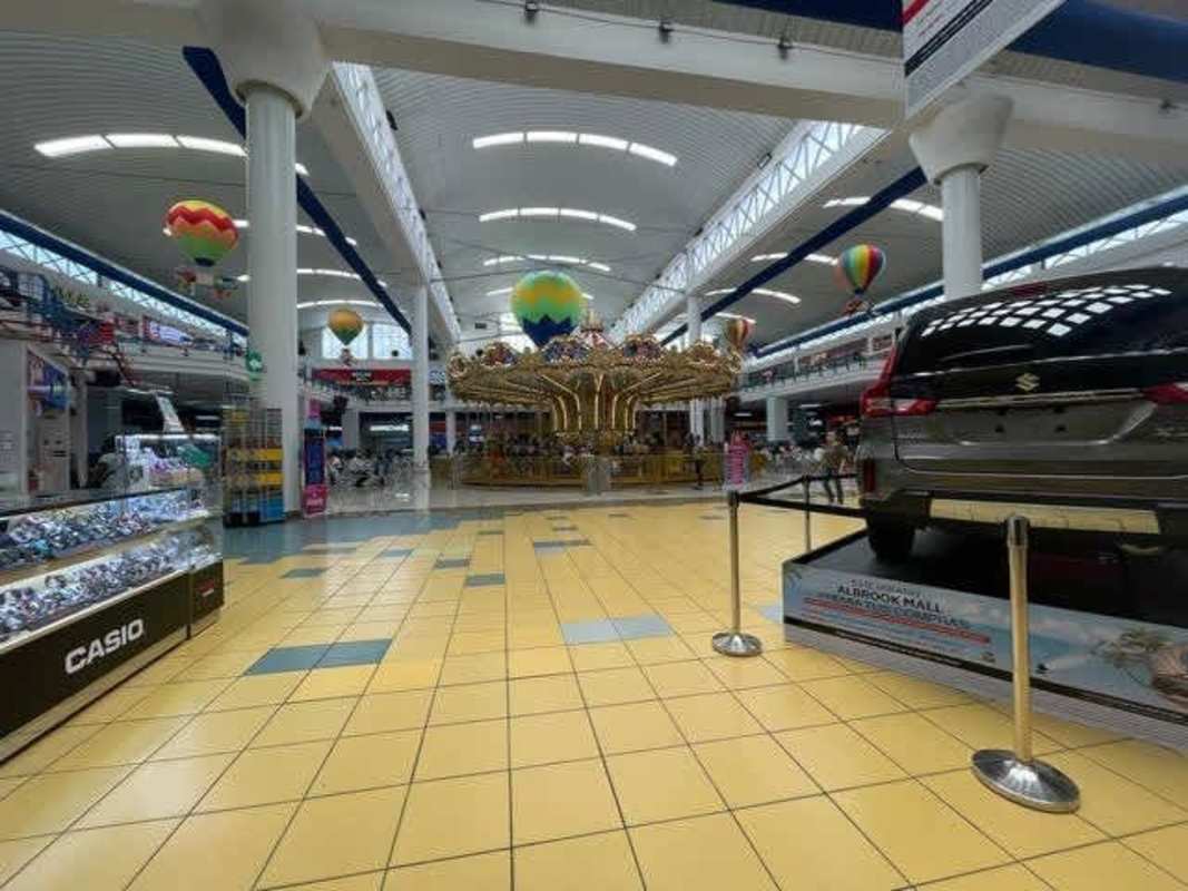 Two-story interior of Albrook Mall with retail shops, escalators, and skylights in Panama