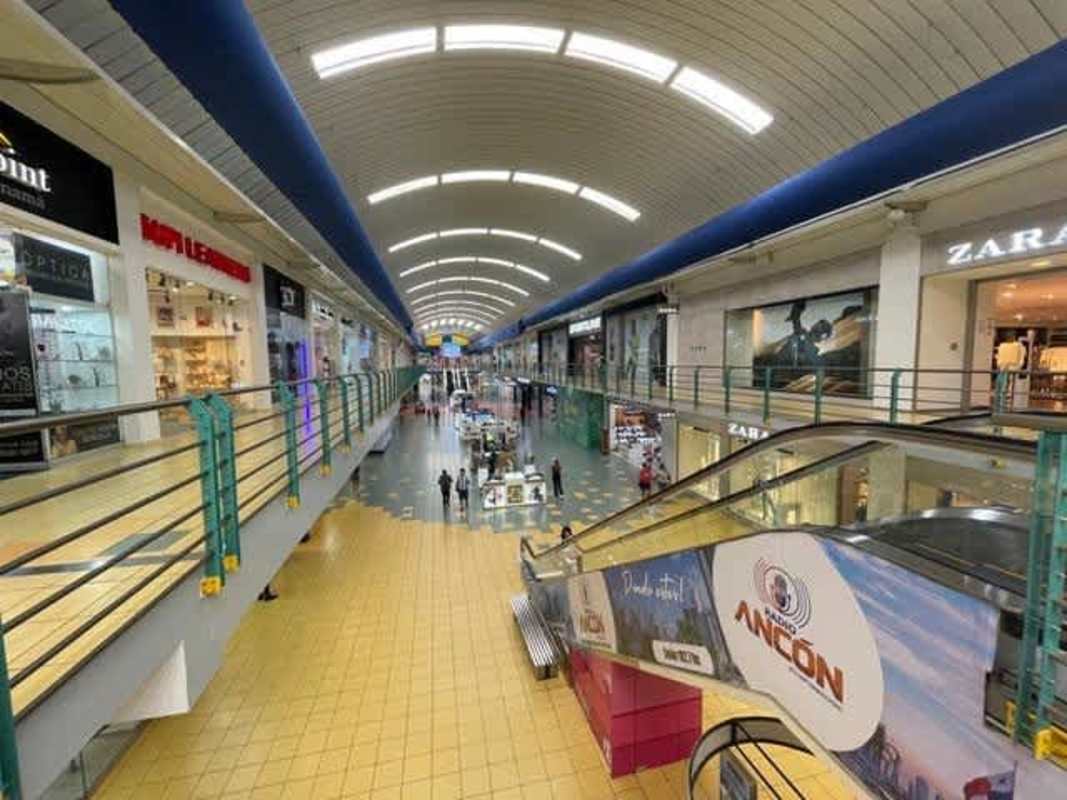 Modern two-level walkway inside Albrook Mall with several retail stores in Panama City