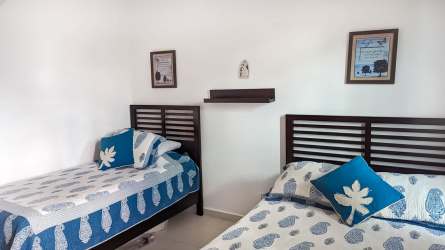 Bedroom with two beds, coastal decor, bright window at PH Howard Bijao Beach Panama