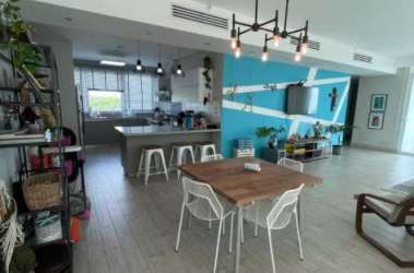 Elegant dining space open to kitchen with modern island at Solea Punta Barco