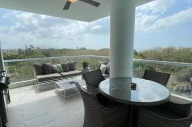 Open-concept living and dining room with large windows and balcony access in Solea Punta Barco