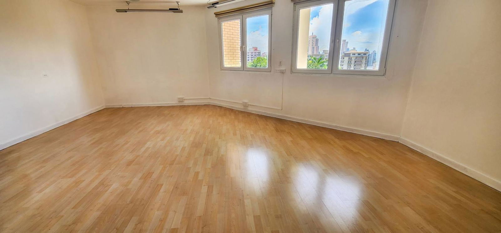 Dining area with wood floors, large windows, city skyline view in PH Vistanova El Cangrejo Panama