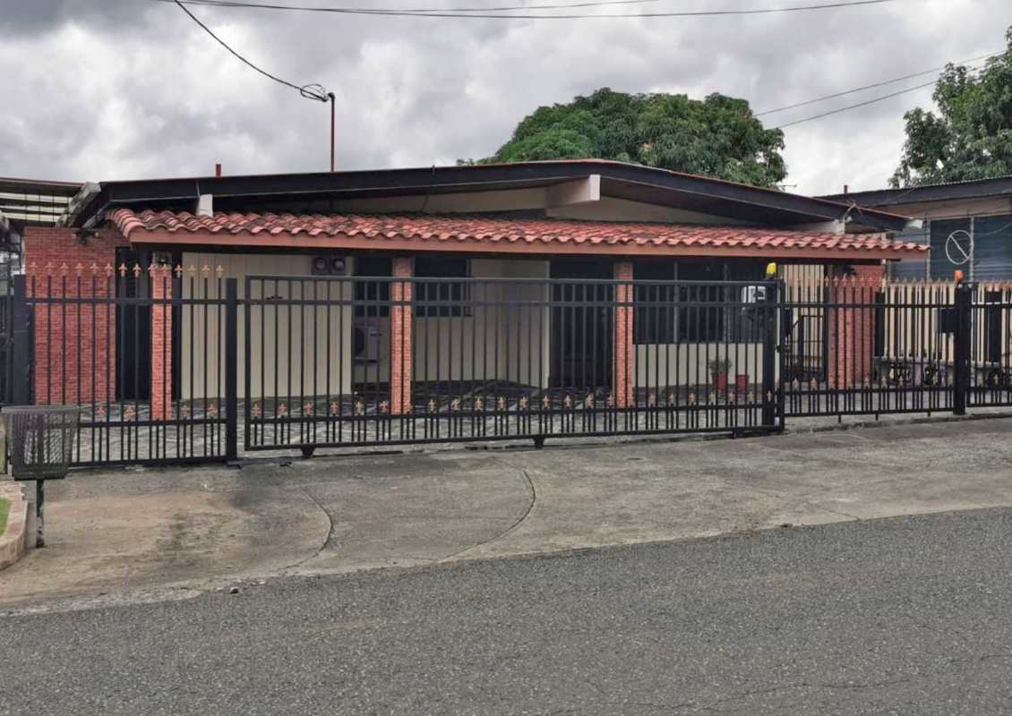 Covered porch, brick columns, metal fence and tiled driveway of Panama house in Club X Bethania