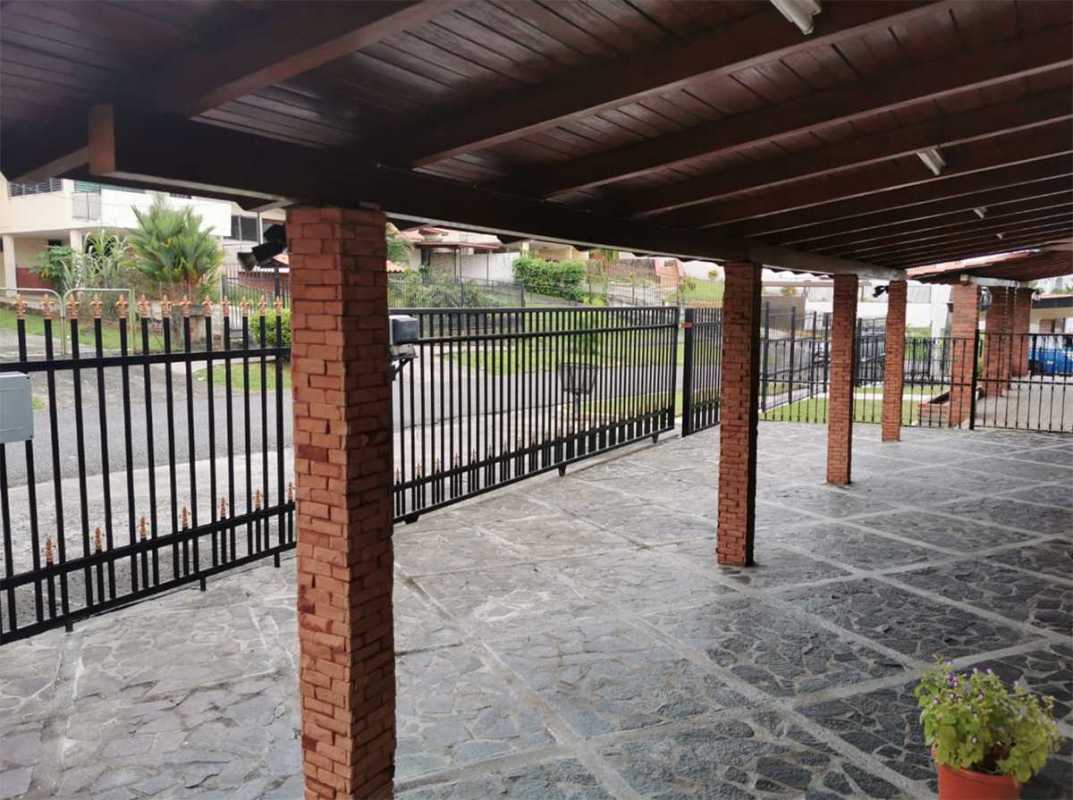 Covered parking with brick columns and metal security gate at home in Club X Bethania Panama