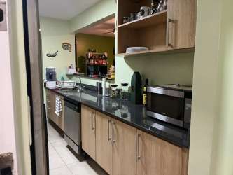 Modern kitchen with granite countertops, wood cabinets, appliances in Bijao Residences Panama