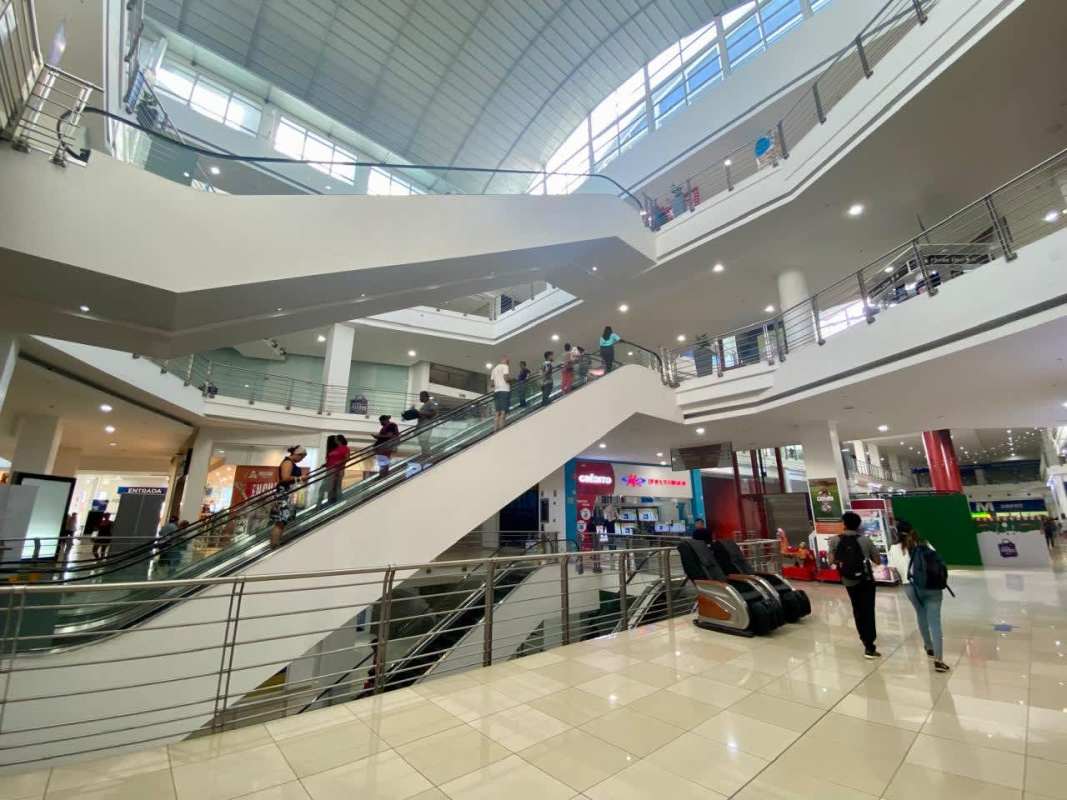 Interior corridor with storefront windows retail kiosks tiled floor Los Andes Mall Panama City