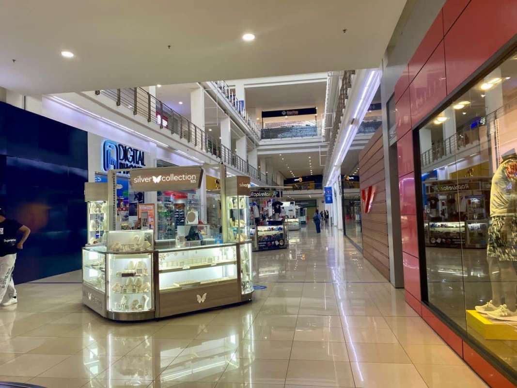 Main facade entrance of Los Andes Mall commercial center with palm trees in Panama City