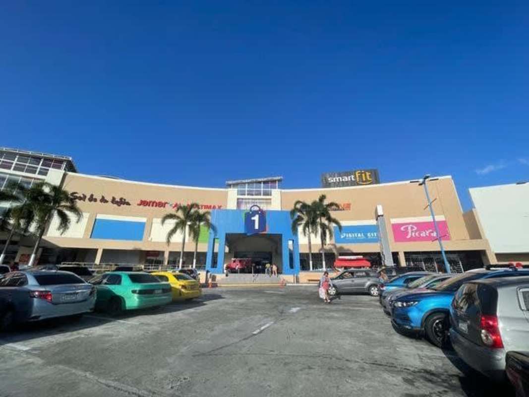 Large parking lot and front exterior of Los Andes Mall Panama with palm trees