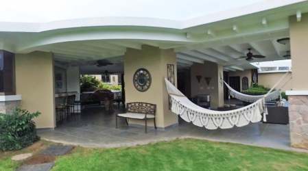 Outdoor patio area with hammock and fans overlooking garden in Sea Cliff Panama estate