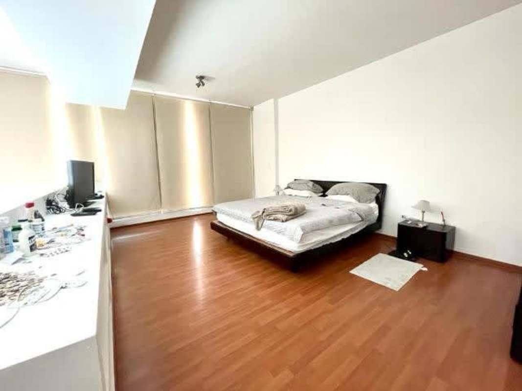 Minimalist master bedroom with wood floors, large windows and ocean view in Loft Four 41 Panama