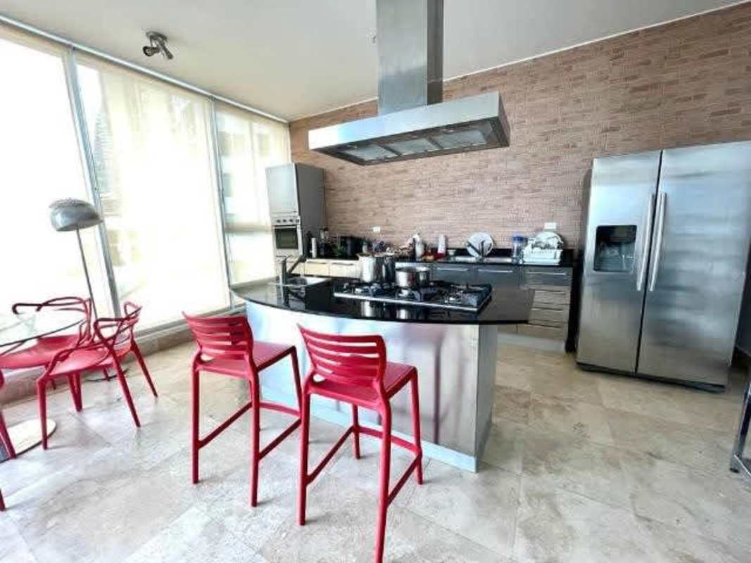 Modern kitchen with island, stainless appliances, red accents and big windows at PH Loft Four 41