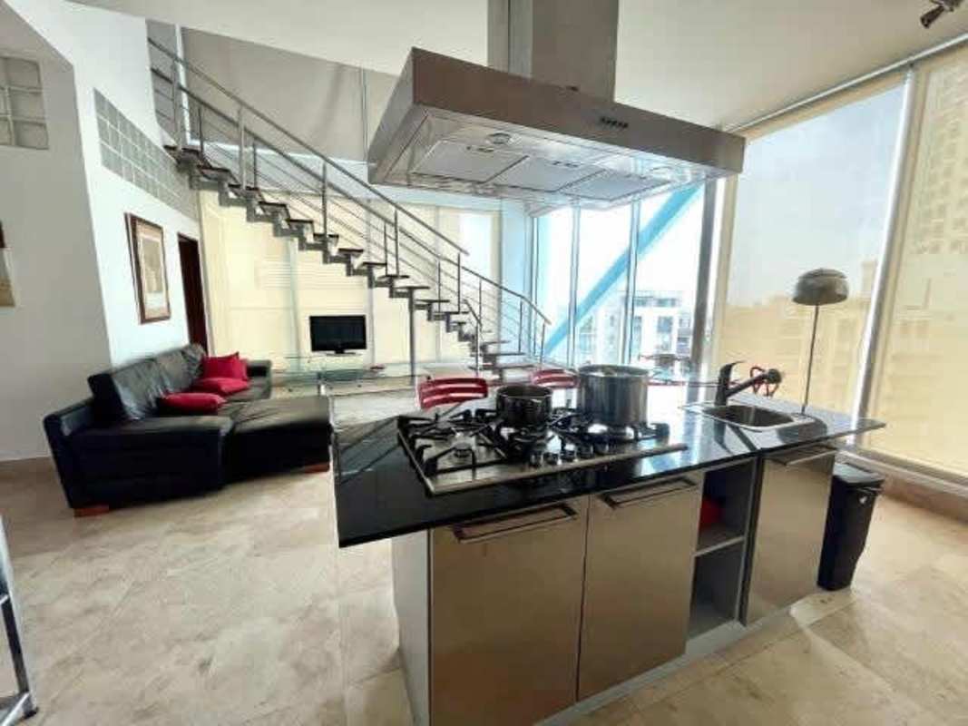 Double-height loft living room with spiral staircase and panoramic windows in PH Loft Four 41 Panama