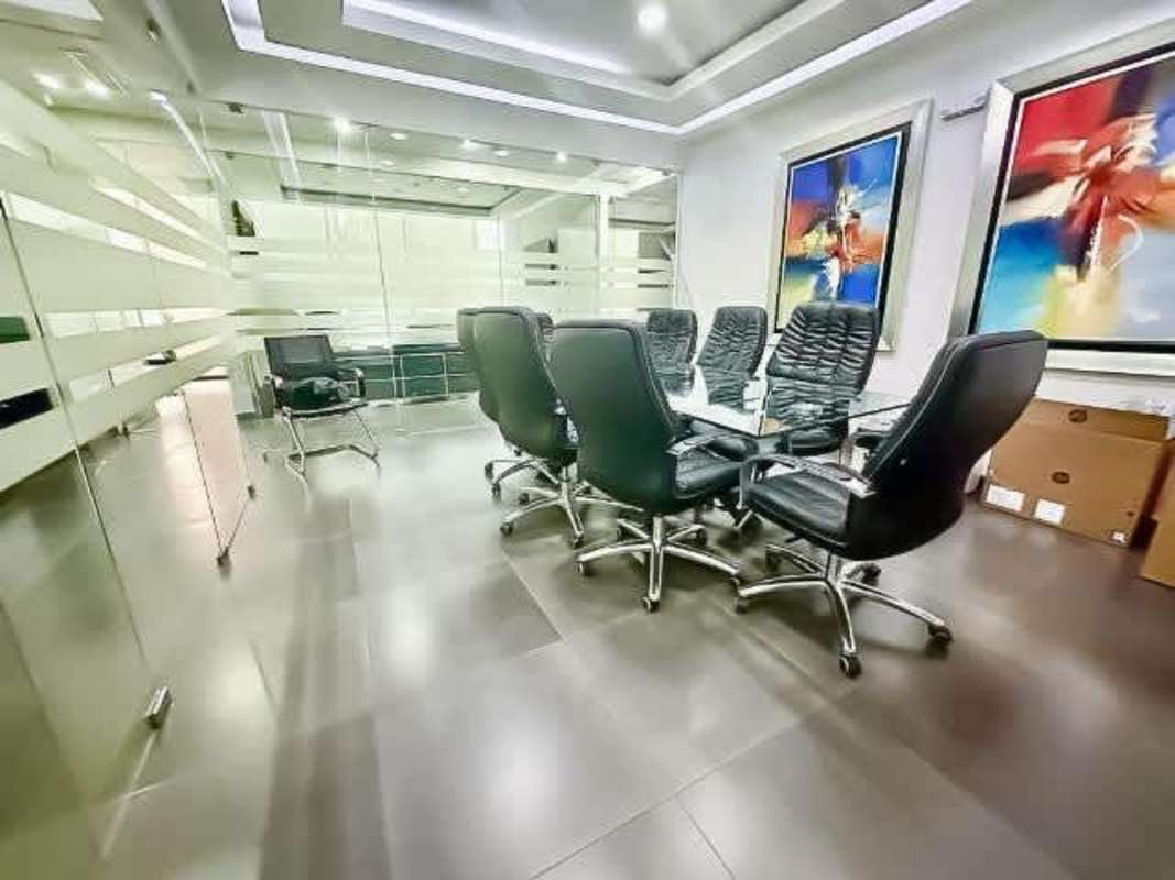 Bright conference room with abstract art, black chairs, and glass walls PH Office One Obarrio