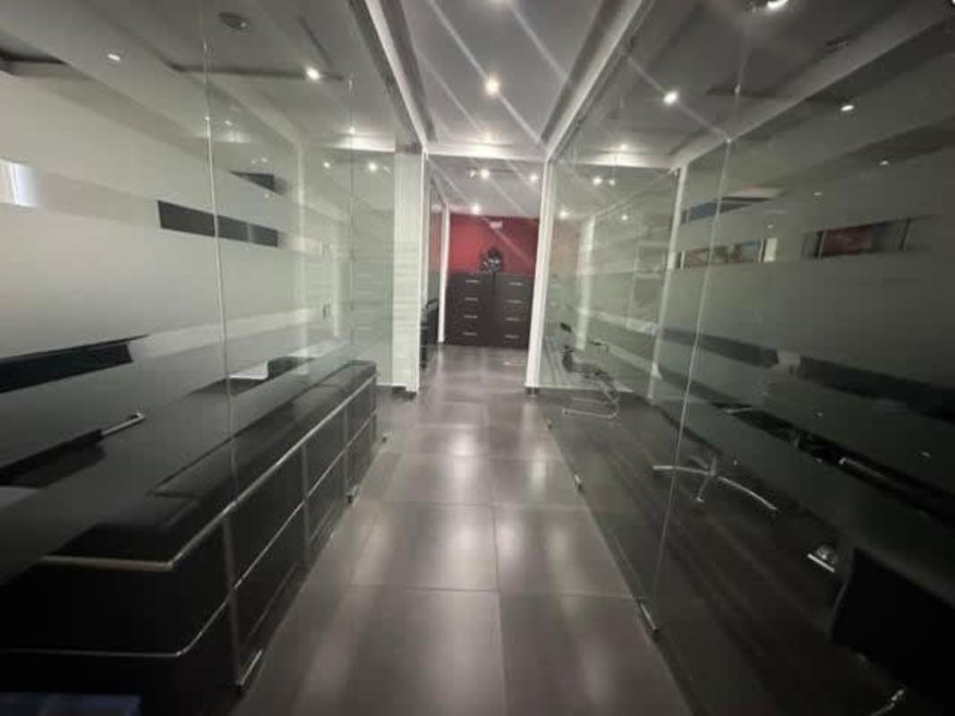 Contemporary office hallway with glass walls and tile flooring PH Office One Obarrio Panama