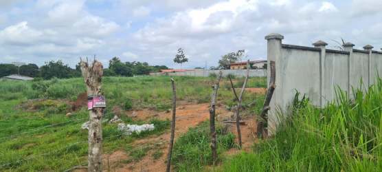 Spacious undeveloped plot with grass and dirt patches fenced for residential project in La Chorrera Panama