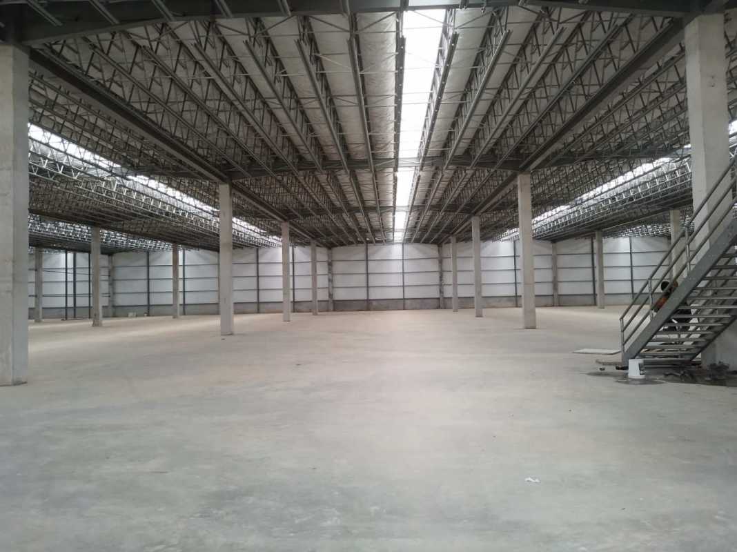 Wide open warehouse interior with insulated sandwich panel walls and 8 meter height in Zona Uno Park