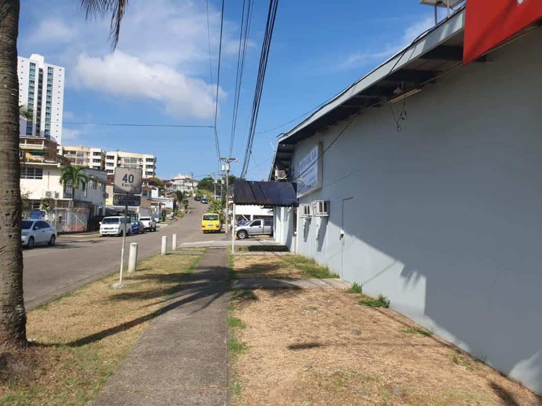 Betania commercial plaza side view with sidewalk, parked cars and shops Plaza Fernand Panama City