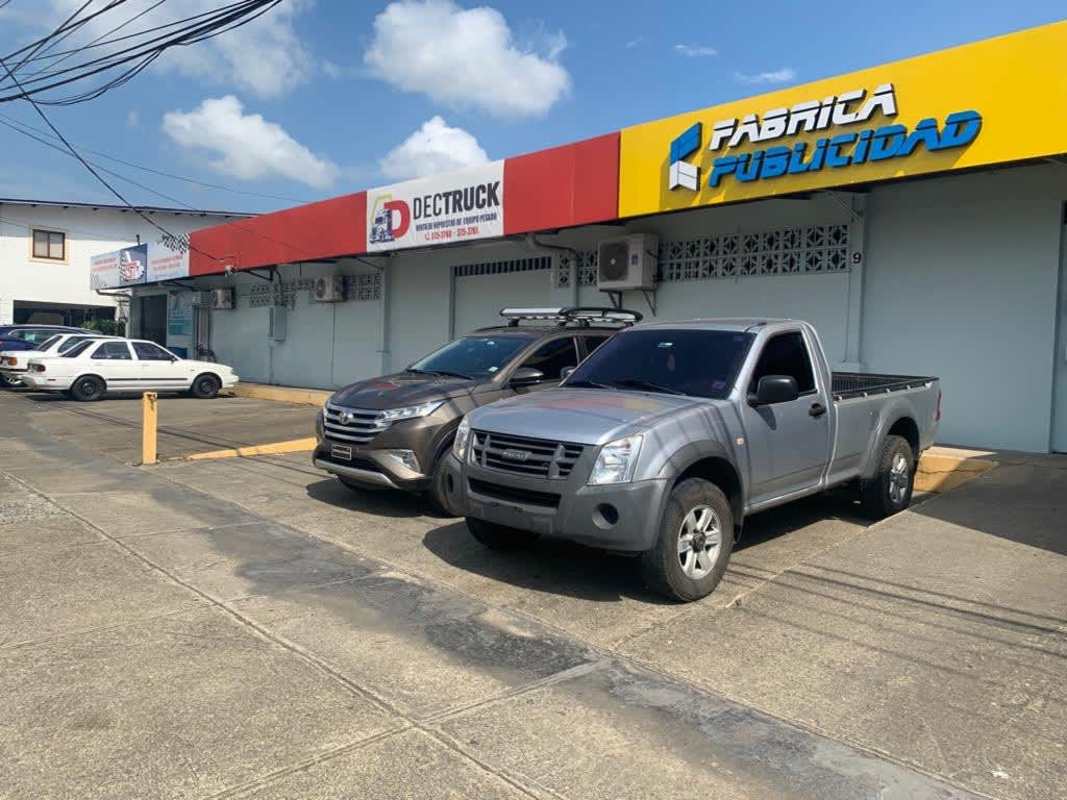 Retail strip frontage Plaza Fernand Betania with parking lot and storefronts on busy avenue Panama City