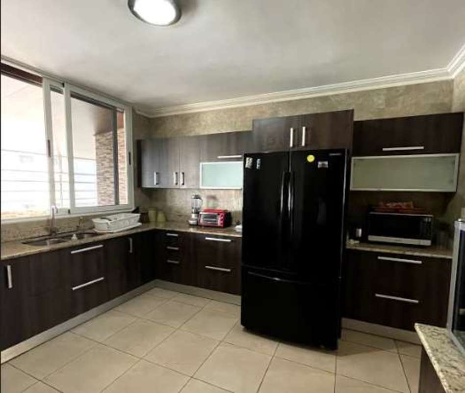 Kitchen with granite counters, dark wood cabinets, large window in PH Torre Marbella, Panama