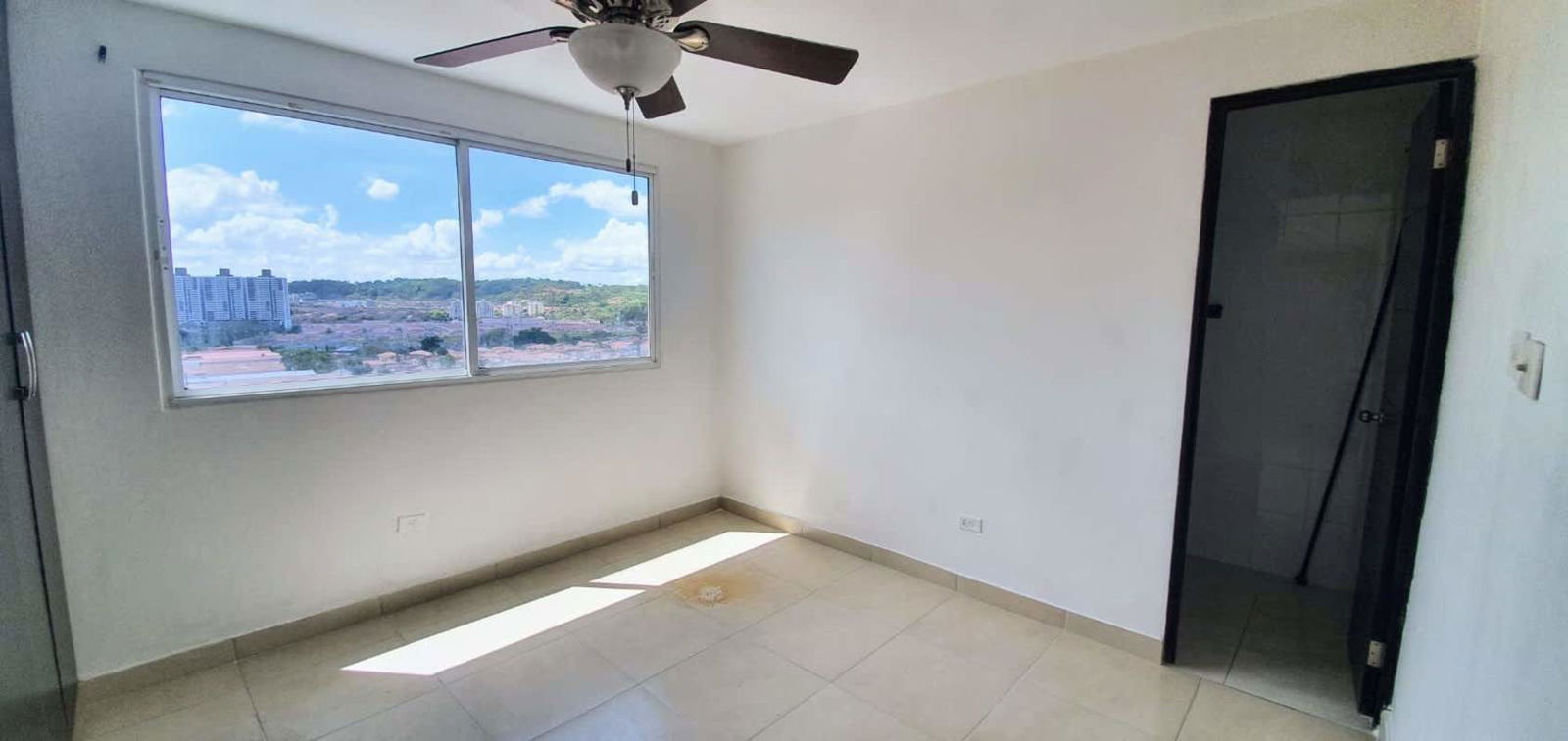 Large bedroom with closet, window and city view in PH Madison Towers Condado del Rey Panama
