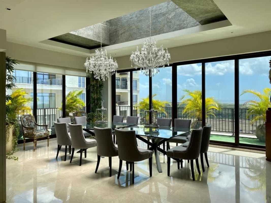 Luxury spacious living room with large panoramic windows, elegant furniture, and city views at Santa María Penthouse