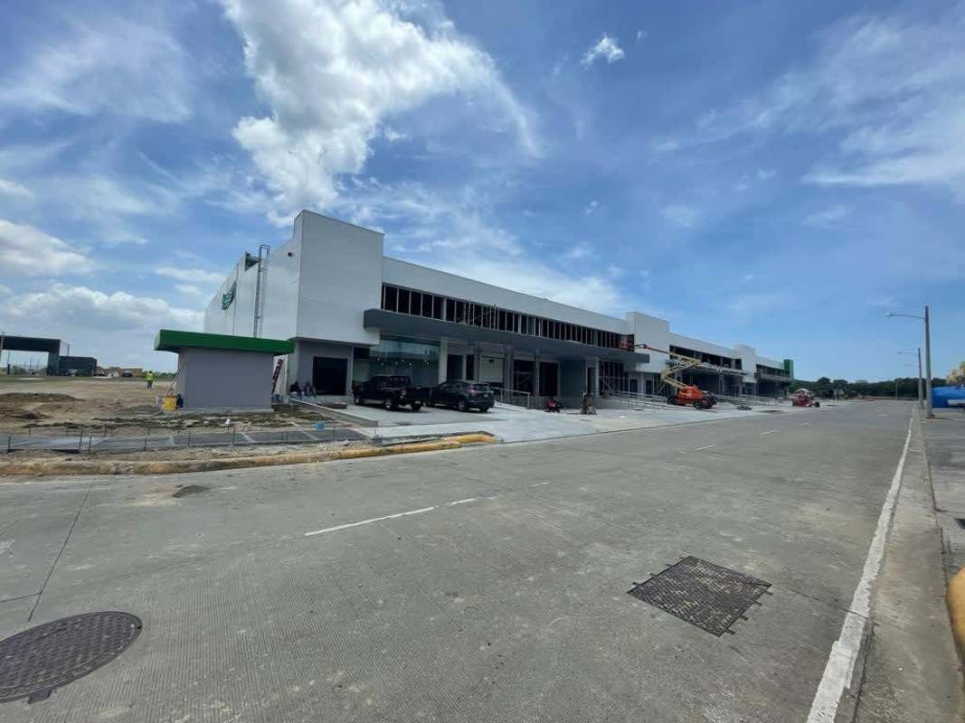Modern two-story commercial warehouse with truck parking under blue sky in Panama