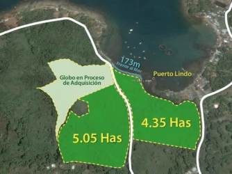 Lush green hills overlooking blue ocean waters with islands on the horizon in Puerto Lindo, Panama