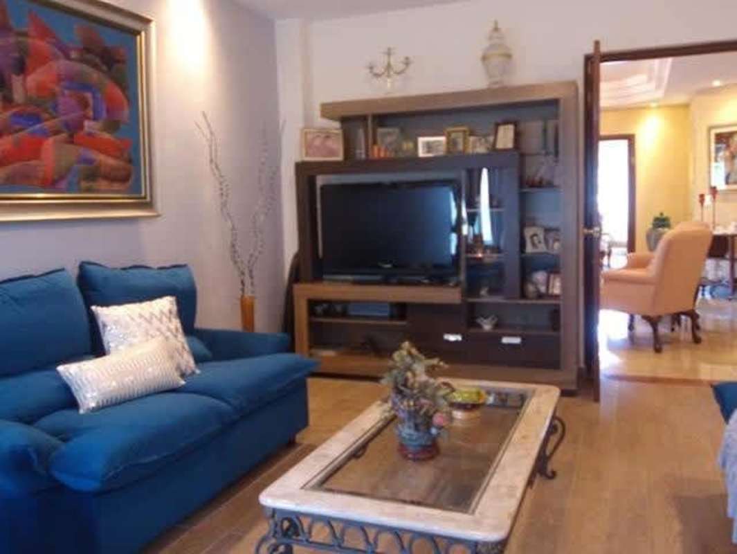 Spacious living room with blue sofa, entertainment center, wood flooring Panama house for sale