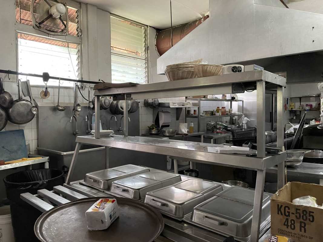 Industrial kitchen with metal prep tables, shelves, and exhaust hood in Panama City commercial