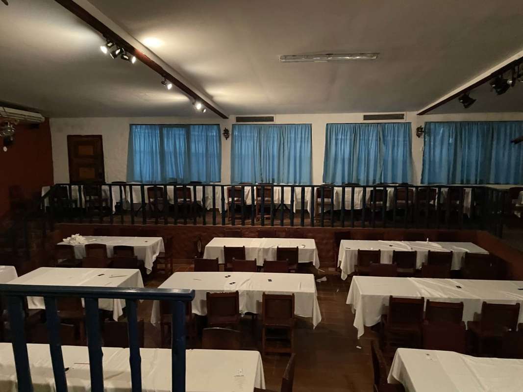 Tiered dining space with wooden handrails and blue curtains inside Panama City restaurant