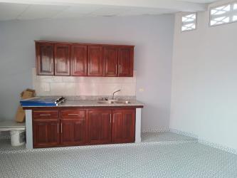 Simple kitchen with wood cabinetry and tiled flooring in Las Tablas house for sale