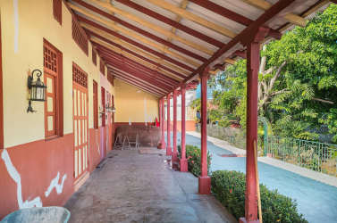 Rustic covered porch overlooking front garden area on Panama real estate listing