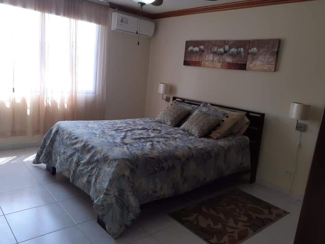 Modern bedroom with large window, bed, and wall art in PH Torre Ebelle Bella Vista Panama City