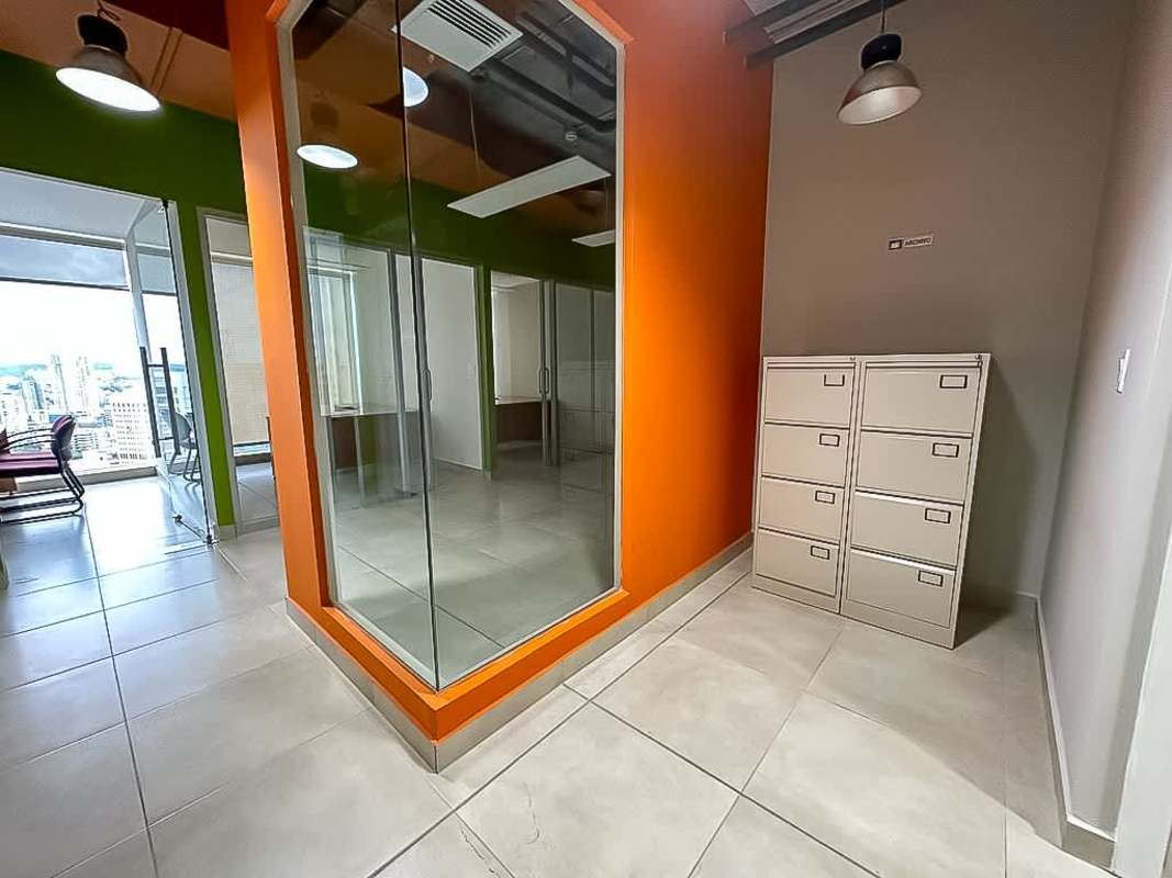 Open workspace with glass walls, exposed ceiling ducts, industrial style PH Sortis Panama
